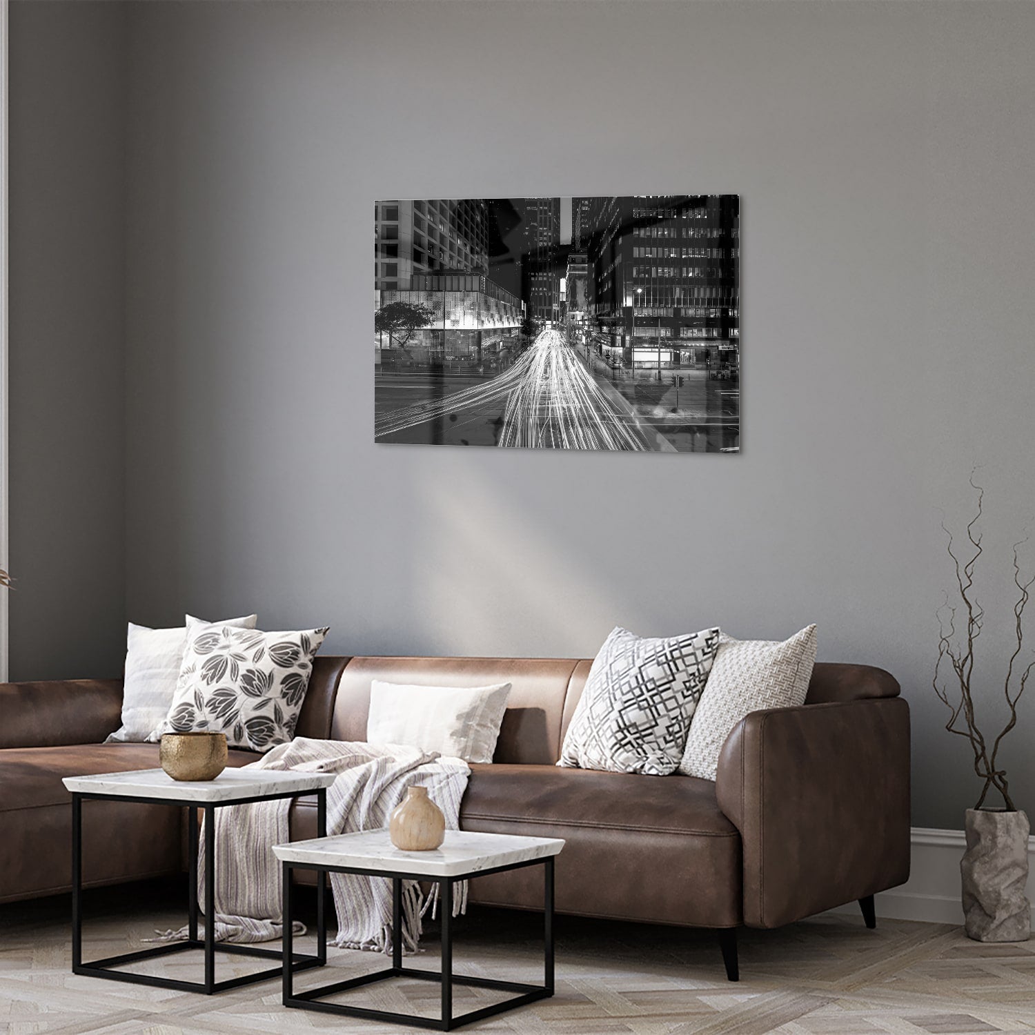 Glazen schilderij met stadslichten in zwart-wit boven een moderne meubelset.