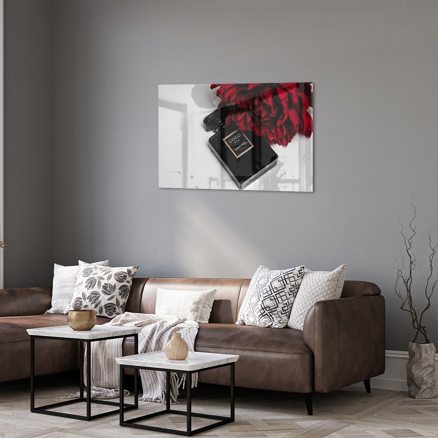 Glazen schilderij van parfumfles met rode bloemen op een witte muur