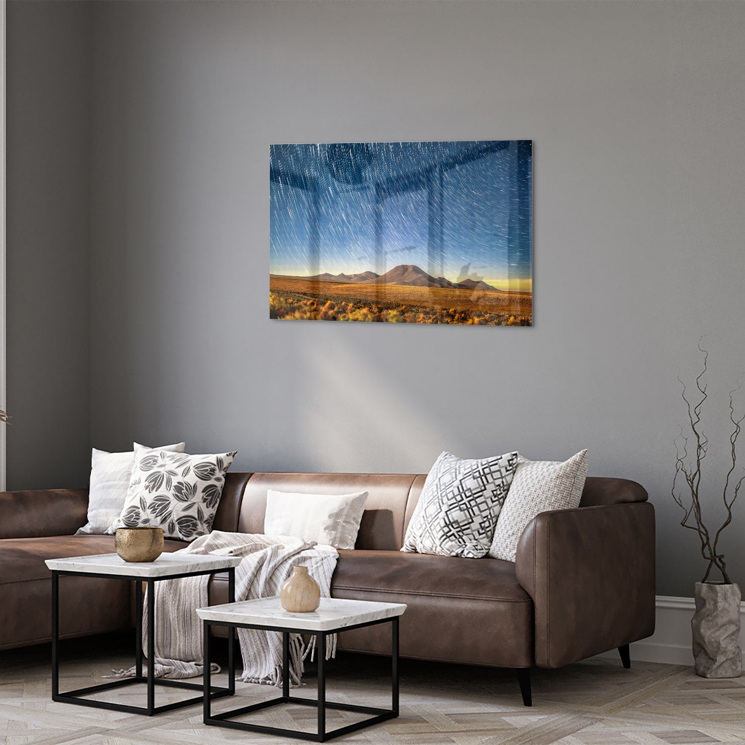 Glazen schilderij met sterrenhemel boven bergen, hangend aan de muur.