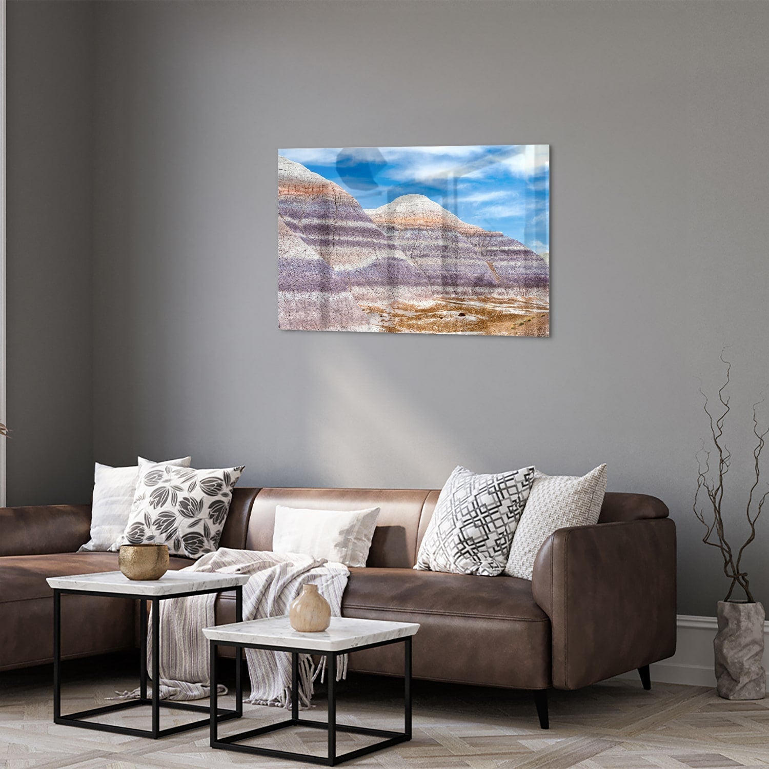 Glazen schilderij van bergen met een blauwe lucht in een moderne woonkamer.