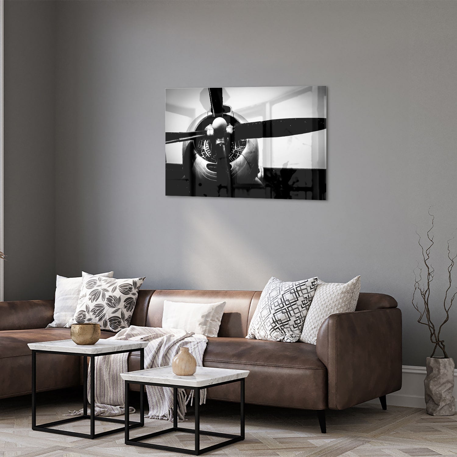 Zwart-wit glazen schilderij van een vintage vliegtuigpropeller tegen een lichte muur.