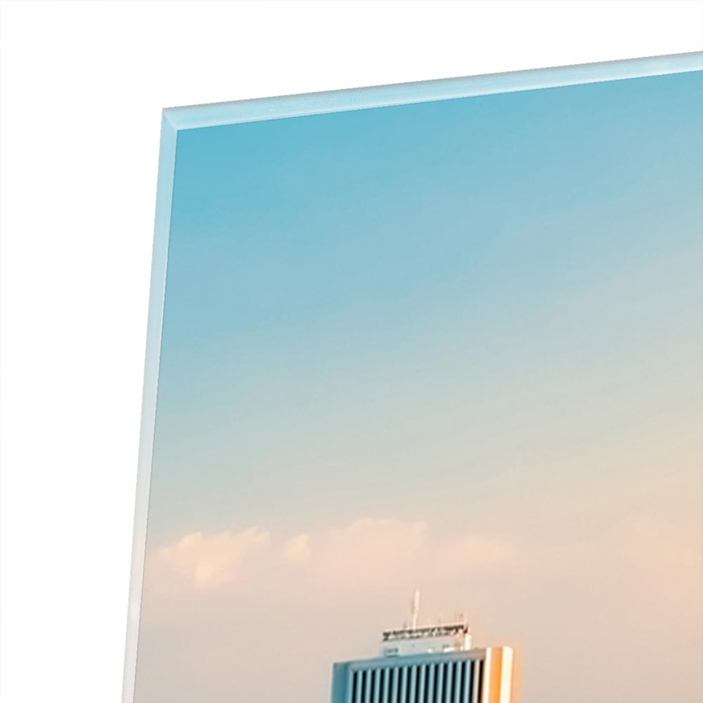 Glazen schilderij met uitzicht op een stad skyline onder een zonsondergang