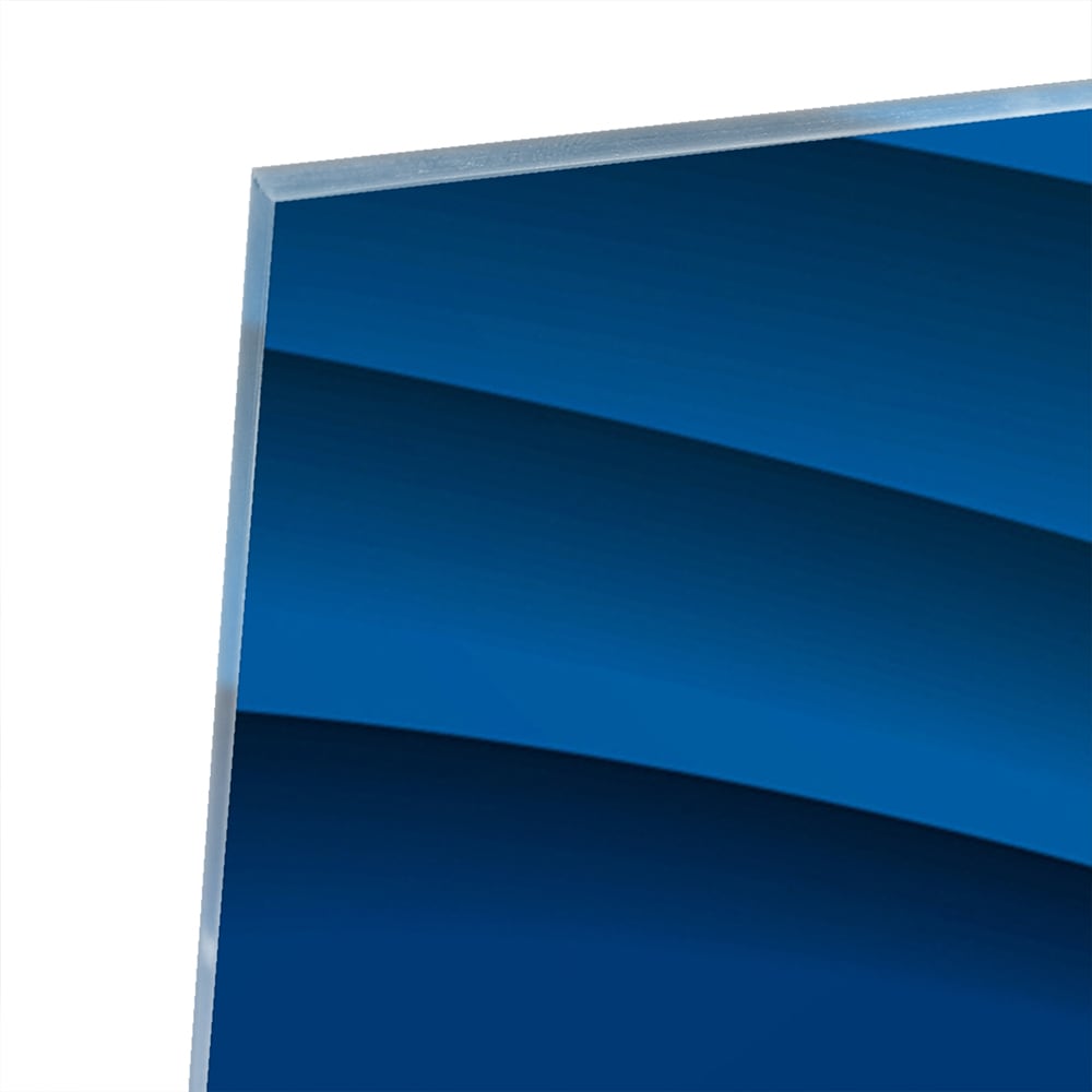 Modern glazen schilderij in abstracte blauwtinten op een muur.