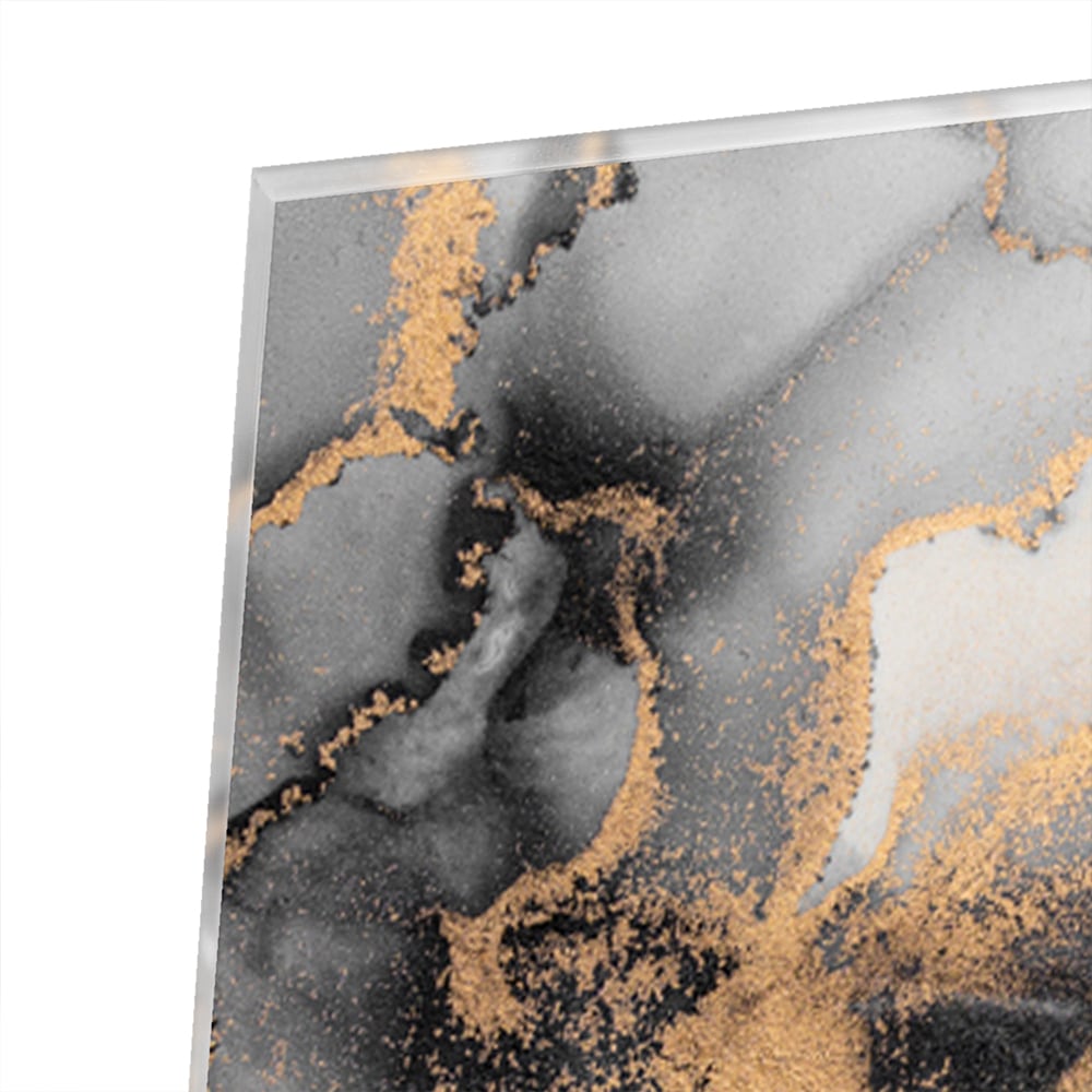 Glazen schilderij met zwarte en gouden abstracte patronen aan de muur boven een houten kast.