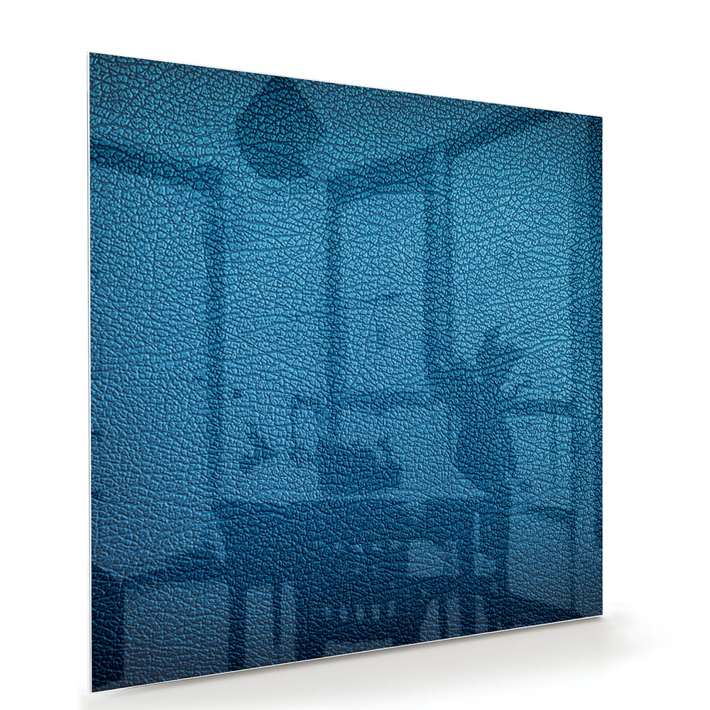 Blauw glazen schilderij met reflecties aan de muur in een moderne woonkamer.