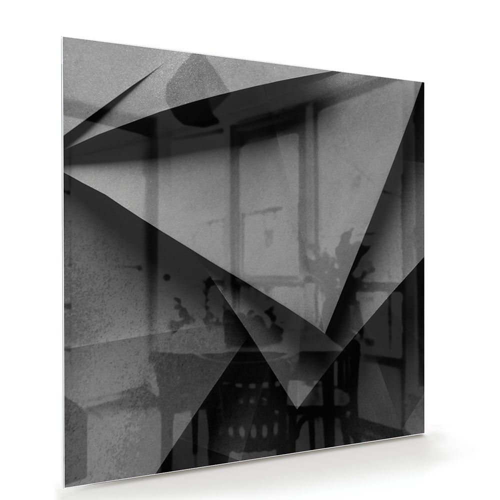 Modern glazen schilderij met een geometrisch zwart-wit ontwerp aan de muur.