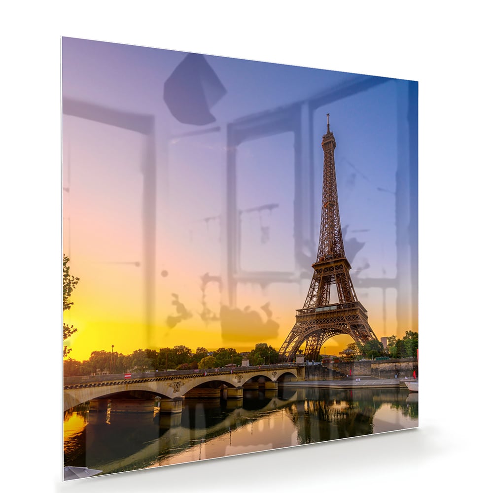 Een glazen schilderij van de Eiffeltoren bij zonsondergang, met warme kleuren.