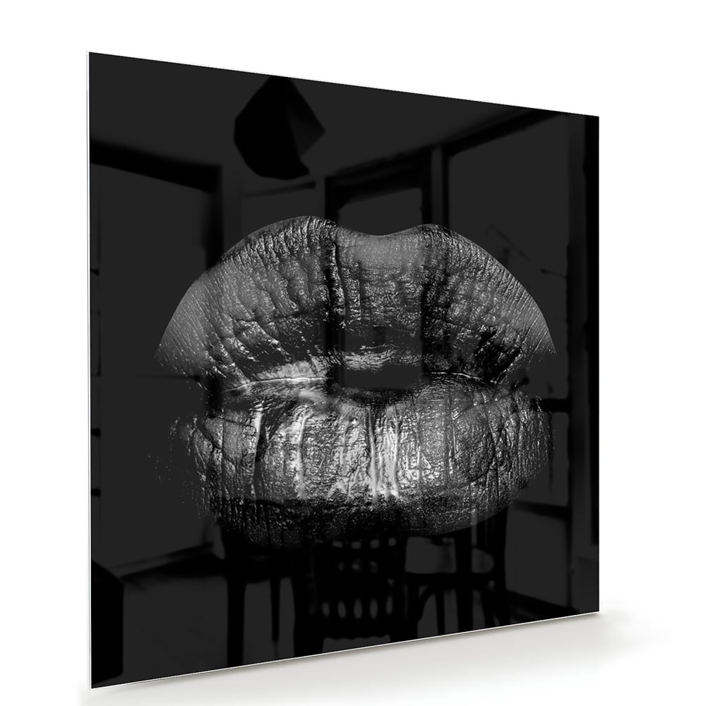 Zwart glazen schilderij met een artistieke lippenprint aan de muur.