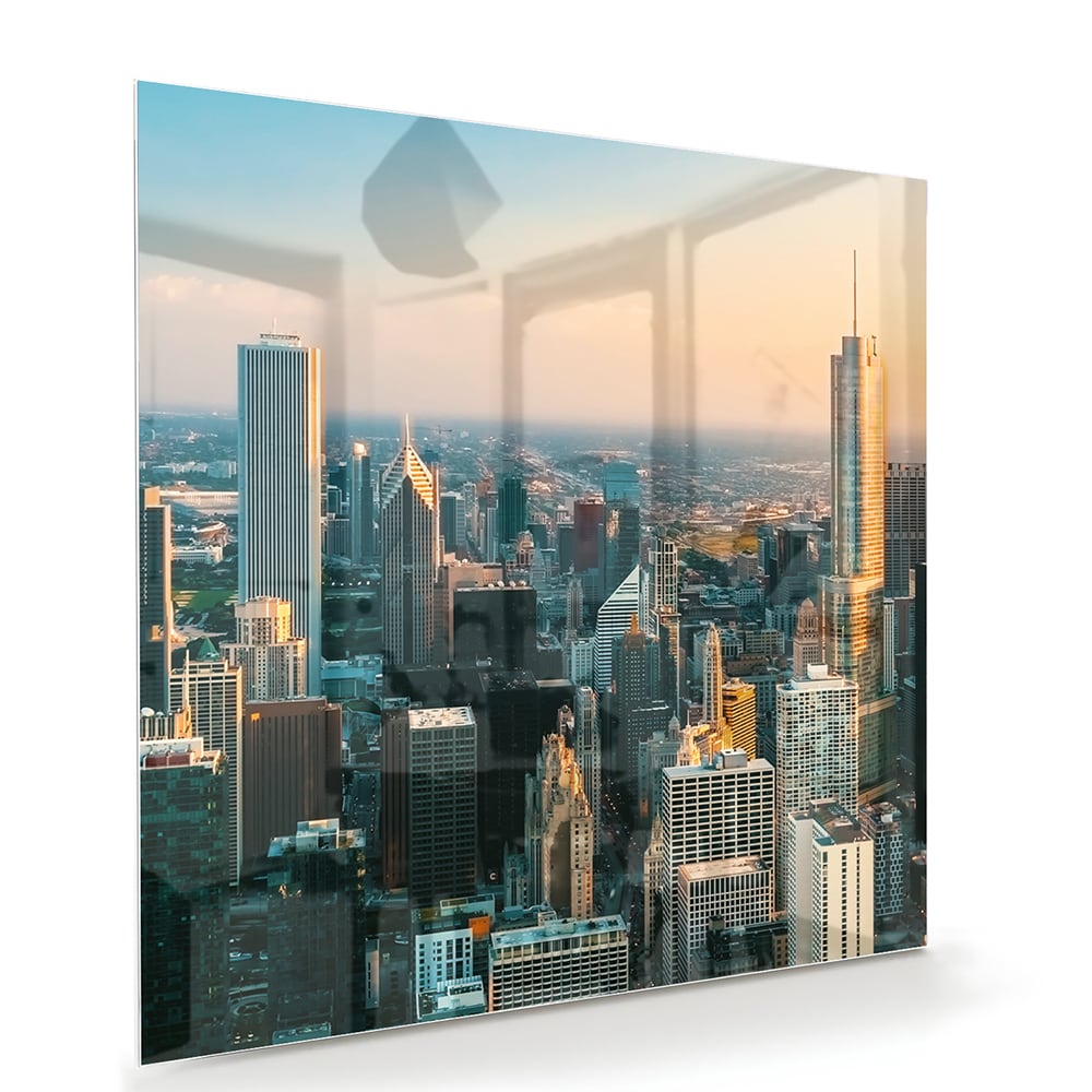 Glazen schilderij met uitzicht op een stad skyline onder een zonsondergang