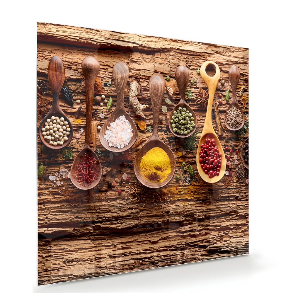 Glazen schilderij met kleurrijke specerijen en houten lepels op een rustieke achtergrond.