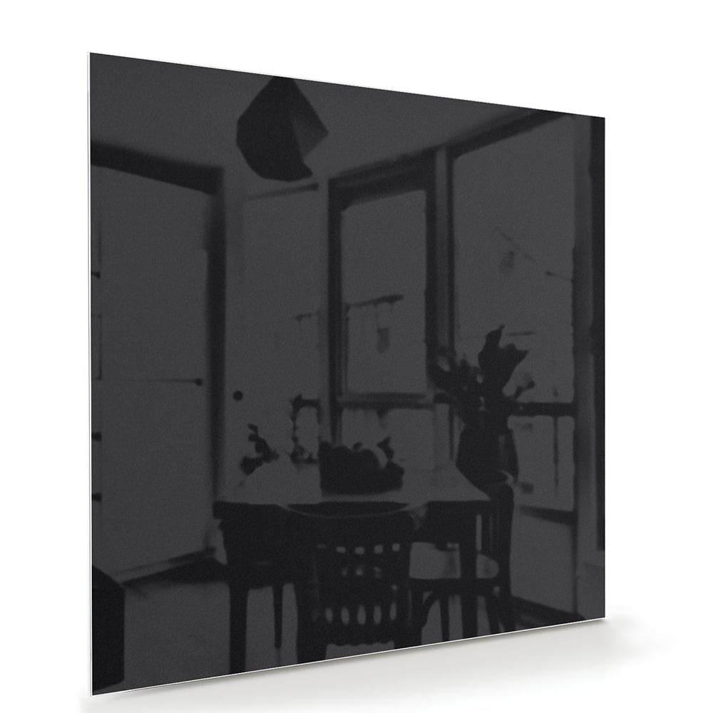 Modern zwart glazen schilderij hangt boven een houten meubel met planten
