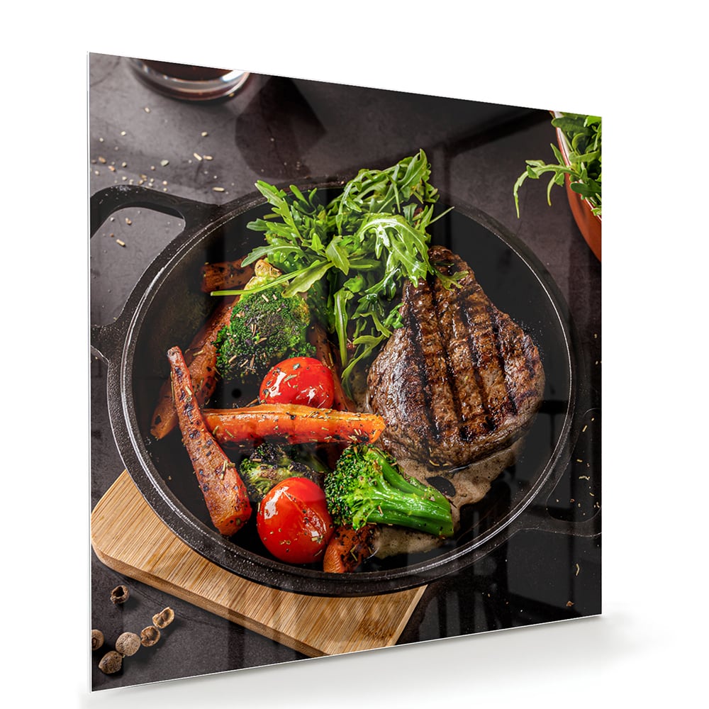 Glazen schilderij met een gegrilde steak en verse groenten in een pan