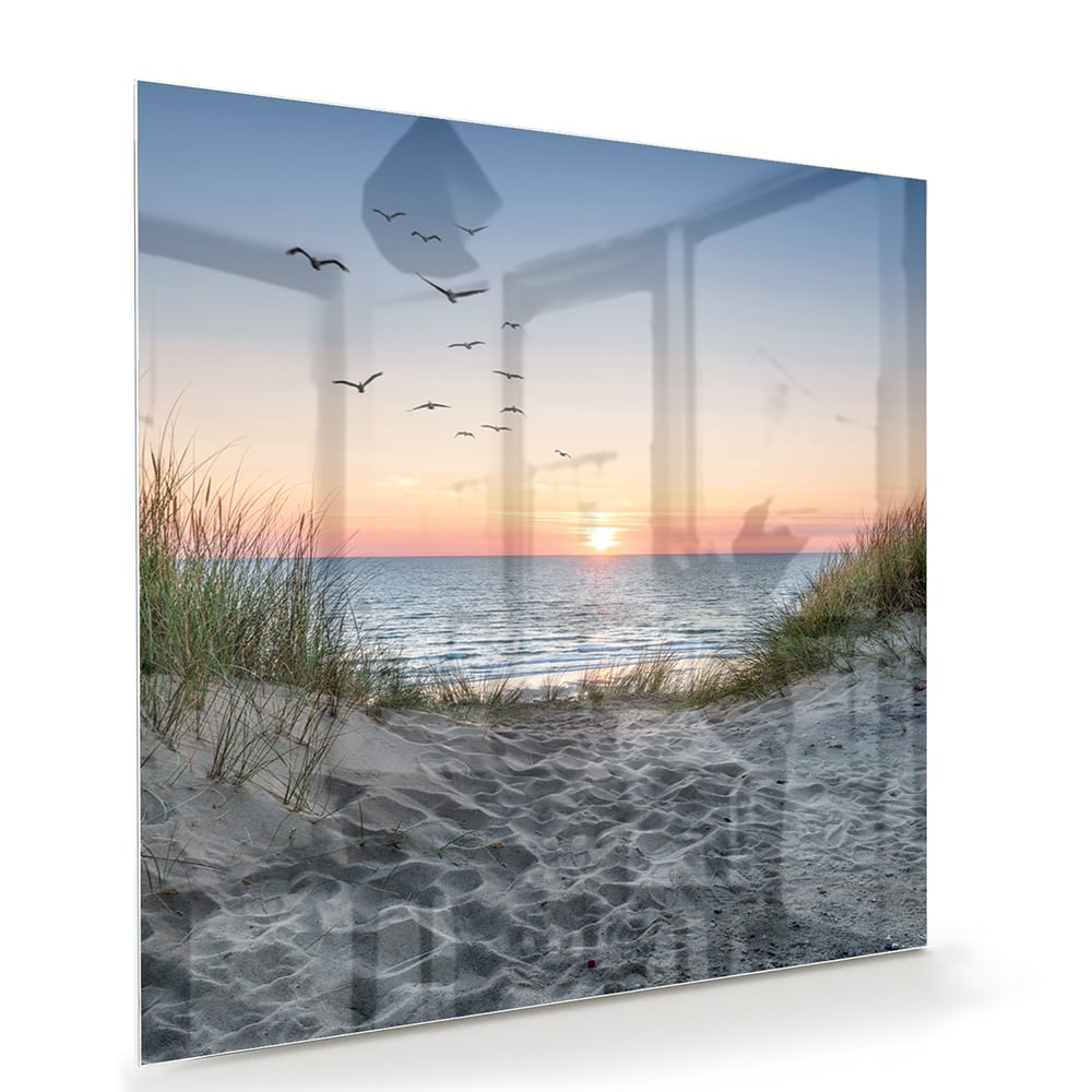 Glazen schilderij van een serene zonsondergang boven de zee met gras en vogels