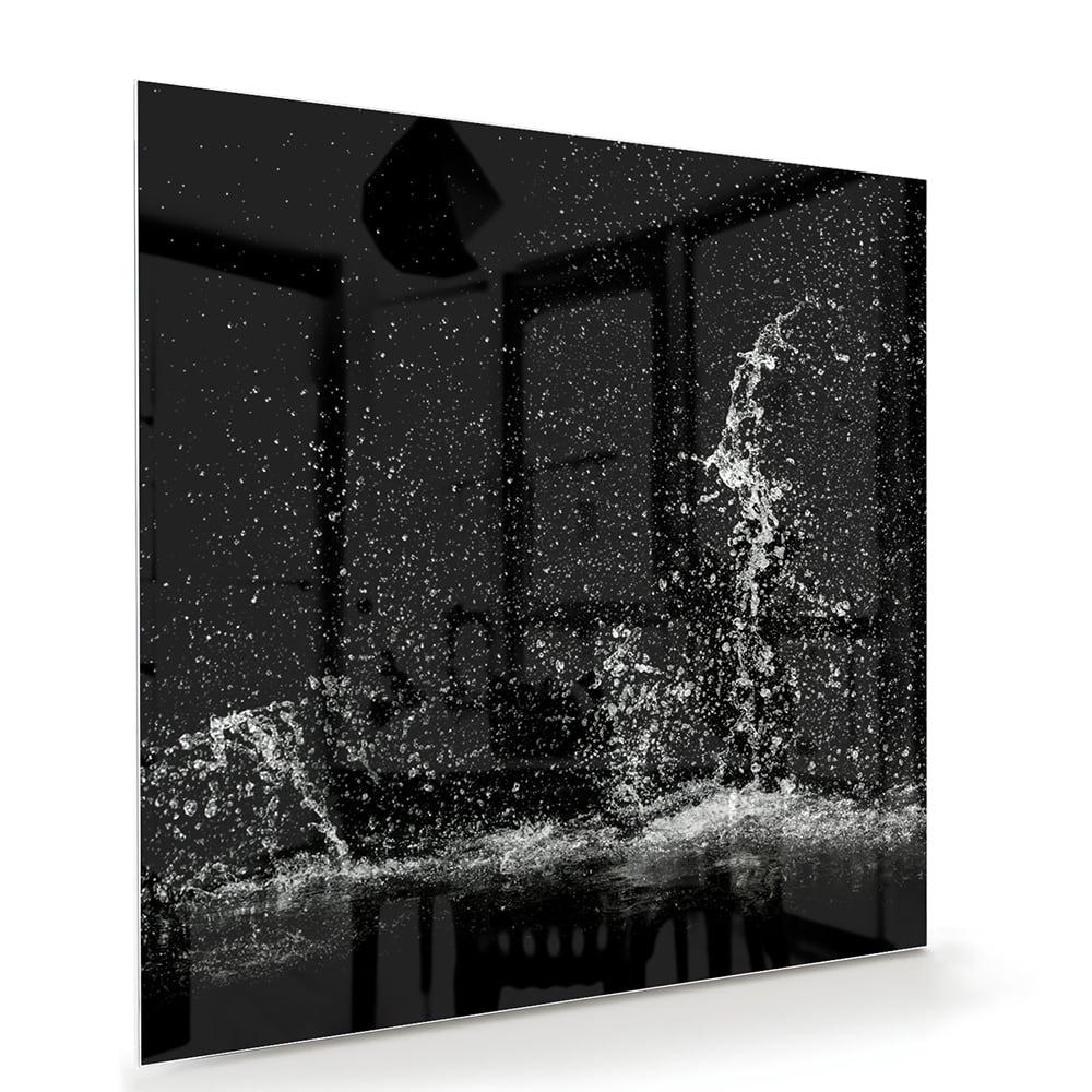 Zwart-wit glazen schilderij met een dynamisch spatwatereffect aan de muur.