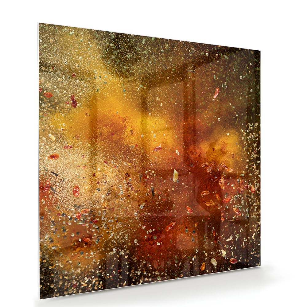 Abstract glazen schilderij met glinsterende warme kleuren in een moderne woonkamer.