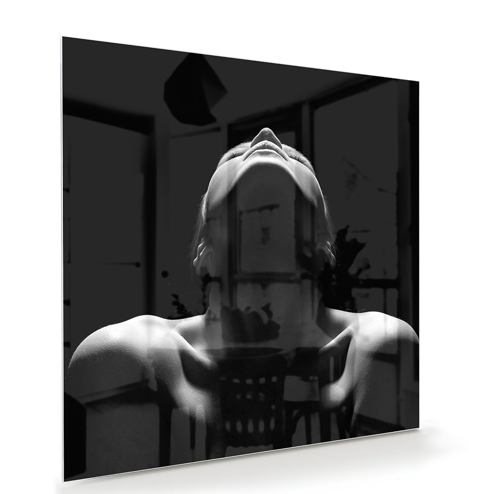 Zwart-wit glazen schilderij met vrouwelijke figuren aan de muur.