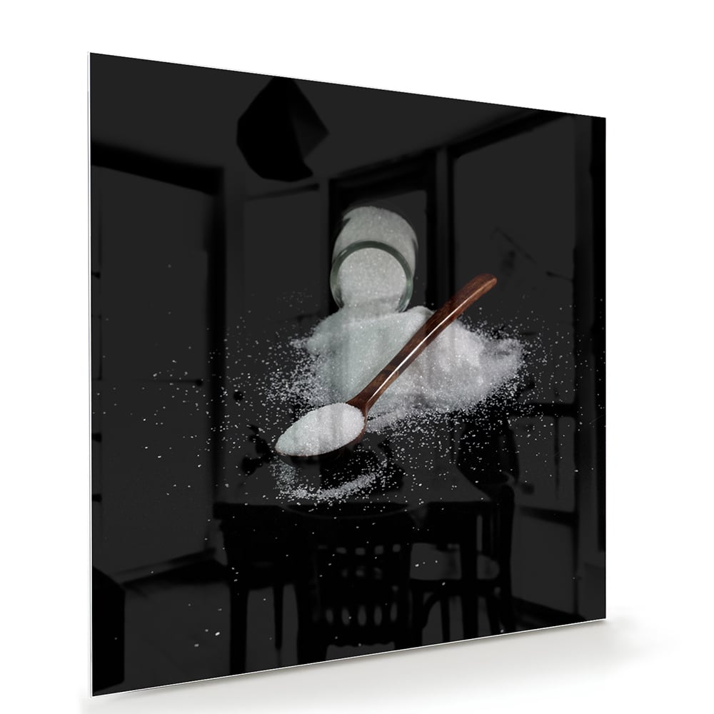 Een glazen schilderij met zout en een lepel op een zwarte achtergrond, ideaal voor keukeninrichting.
