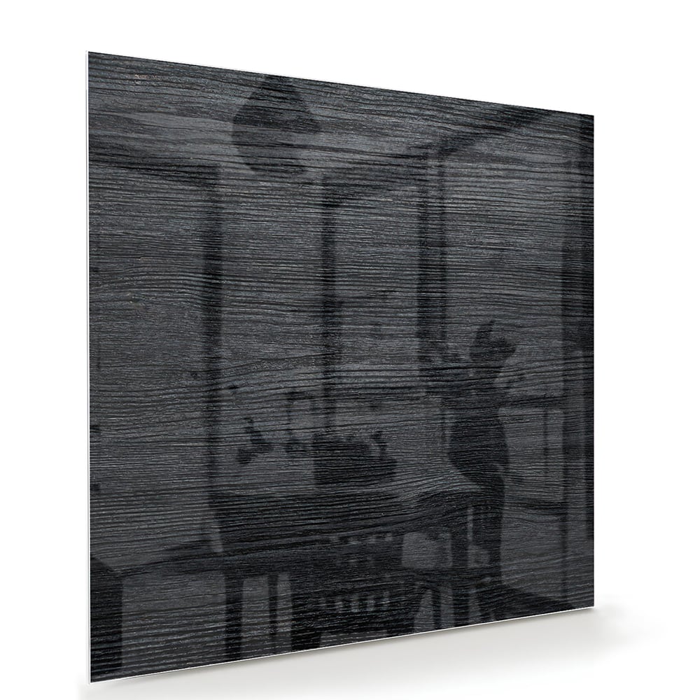 Stijlvol zwart glazen schilderij aan een wand in een moderne woonkamer.
