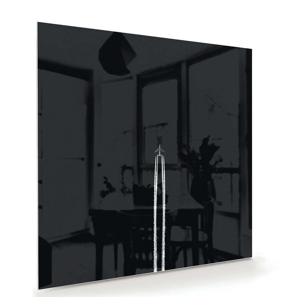 Zwart glazen schilderij aan de muur in een moderne woonkamer met houten meubel.