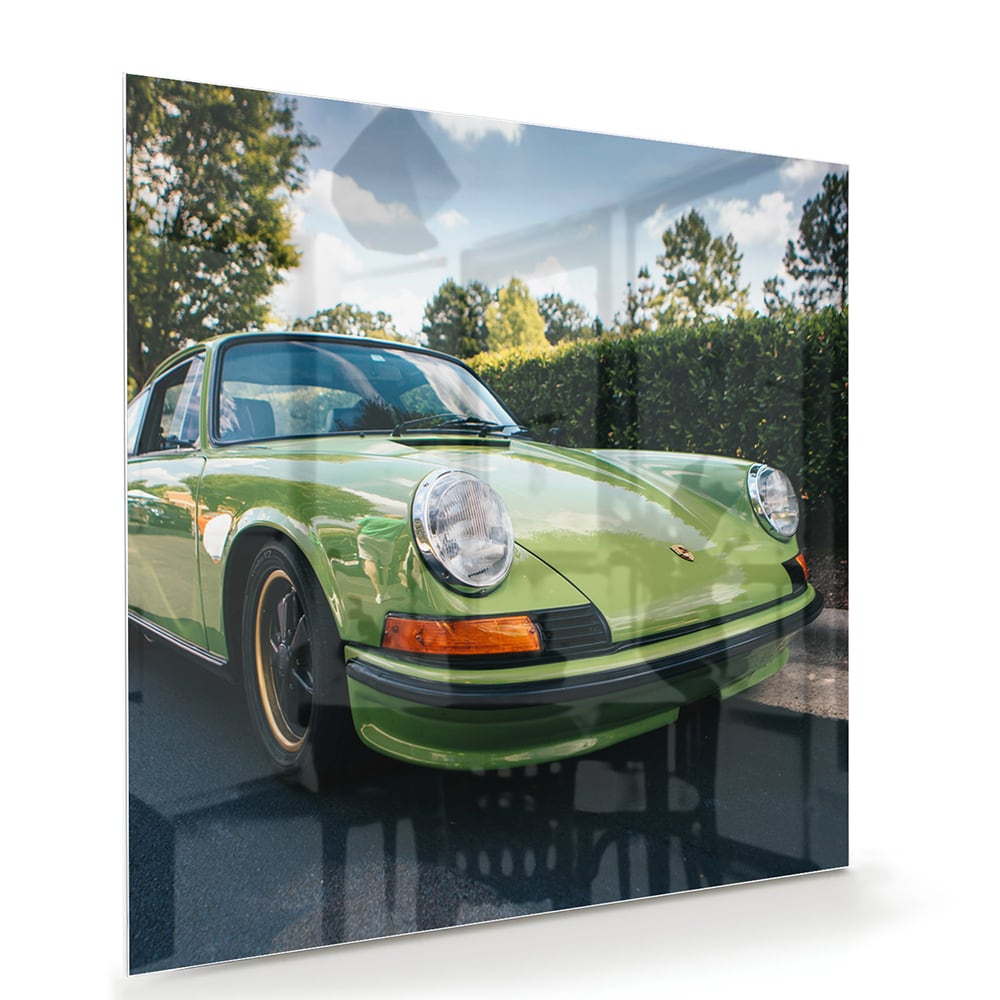 Glas schilderij van een groene Porsche aan de muur in een stijlvol interieur