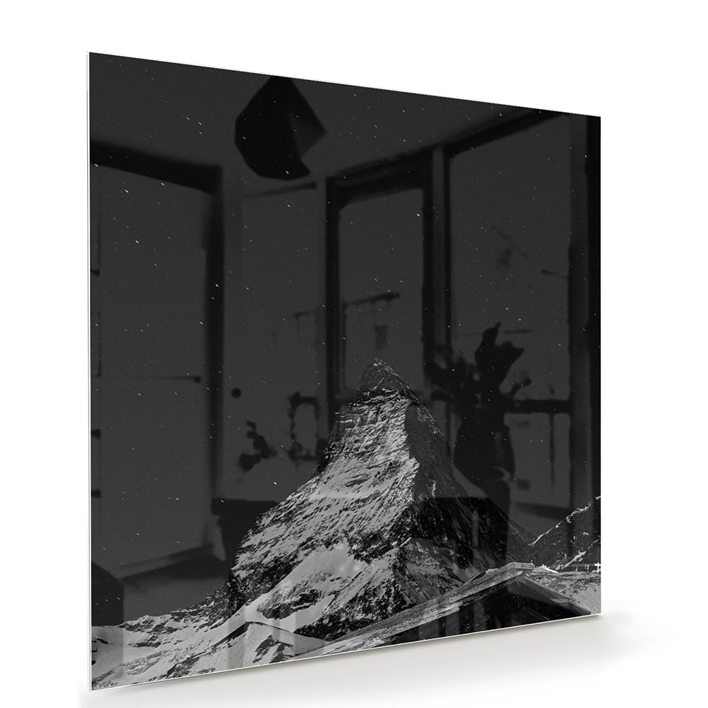 Zwart-wit glazen schilderij met een berglandschap boven een moderne kast