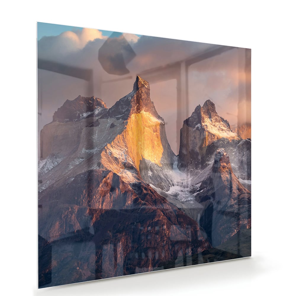 Glazen schilderij met berglandschap aan de muur in een moderne woonkamer