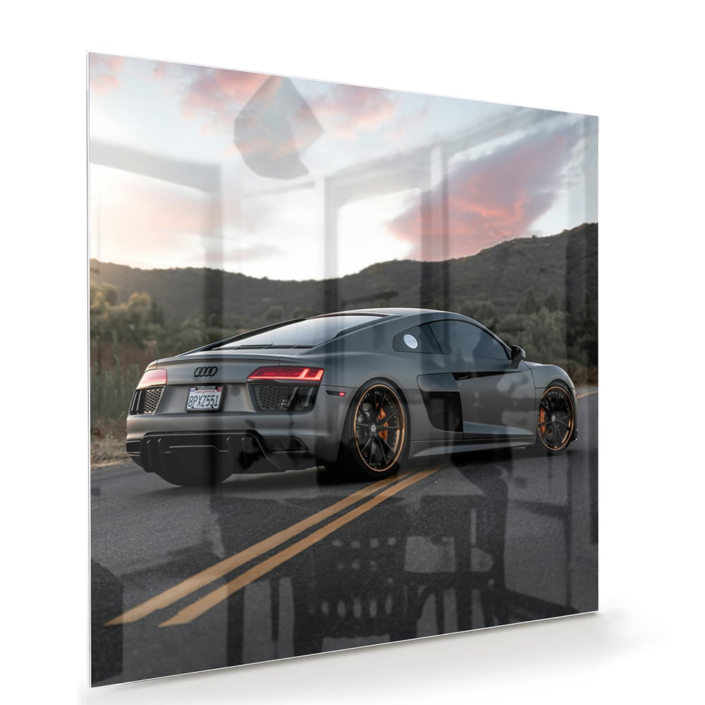 Glazen schilderij van een sportwagen afgebeeld in de natuur met bergen op de achtergrond.