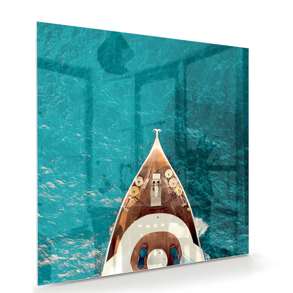Glazen schilderij van een boot die boven helder turquoise water ligt.