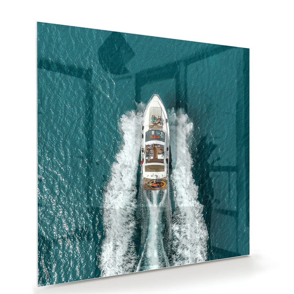 Glazen schilderij van een boot die door turquoise water vaart.