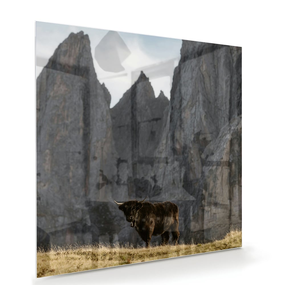 Glas schilderij van bergen met een koe in een groene wei.