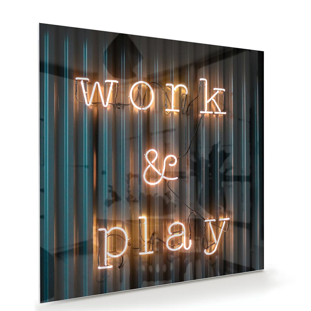 Glazen schilderij met de woorden 'Work & Play' in sfeervolle verlichting.