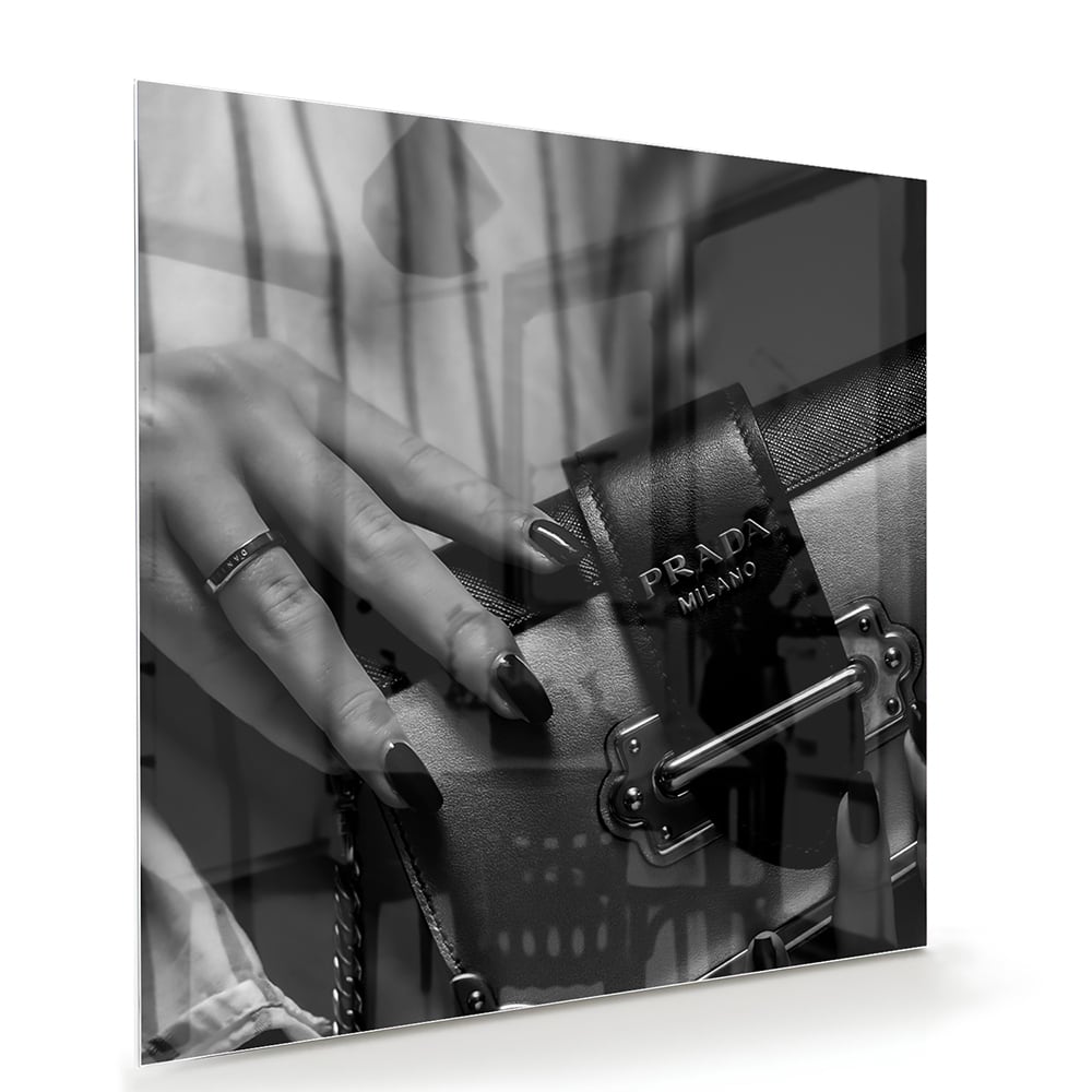 Glazen schilderij met close-up van luxe accessoires op een wand.