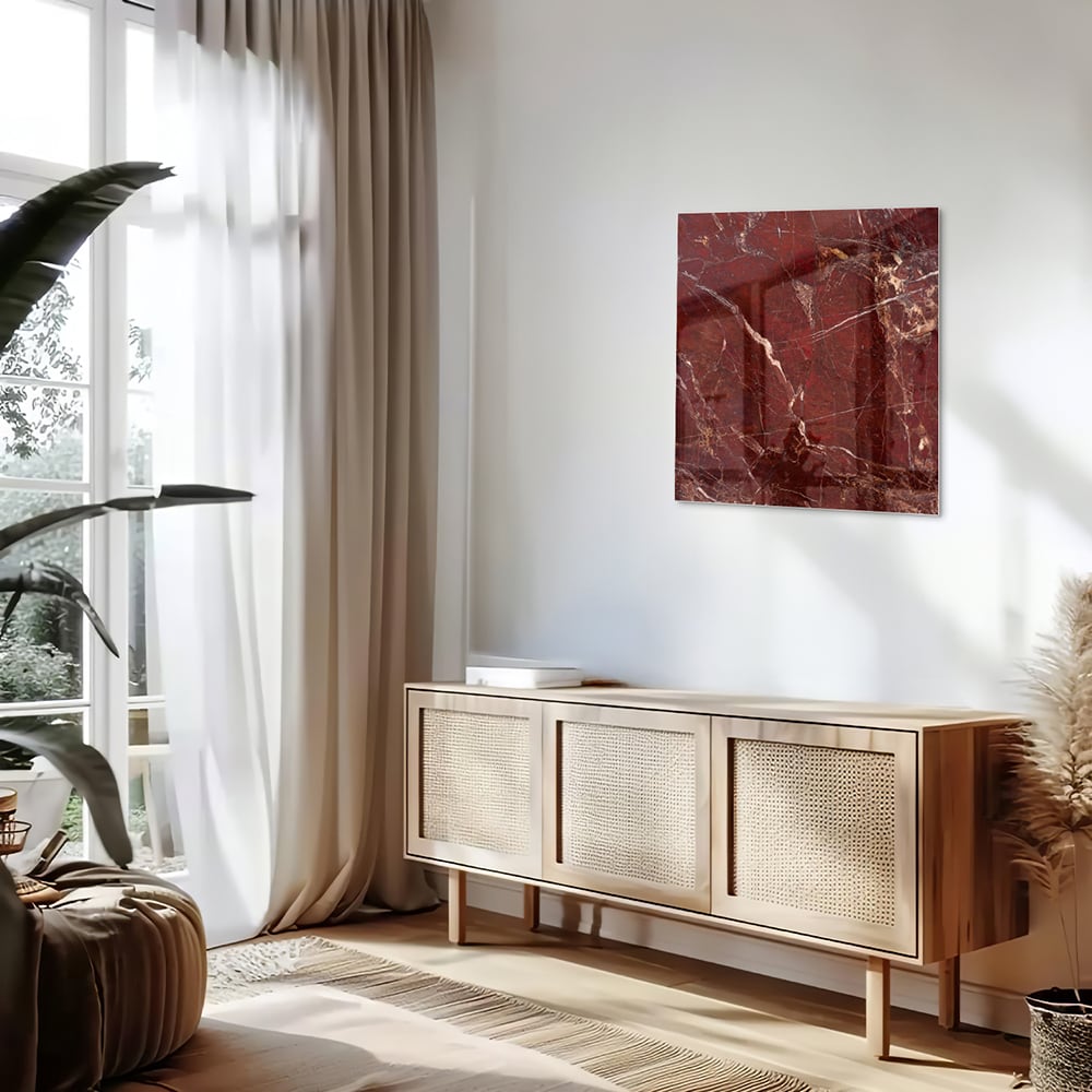 Rood glazen schilderij met marmerlook aan de muur boven een houten kast
