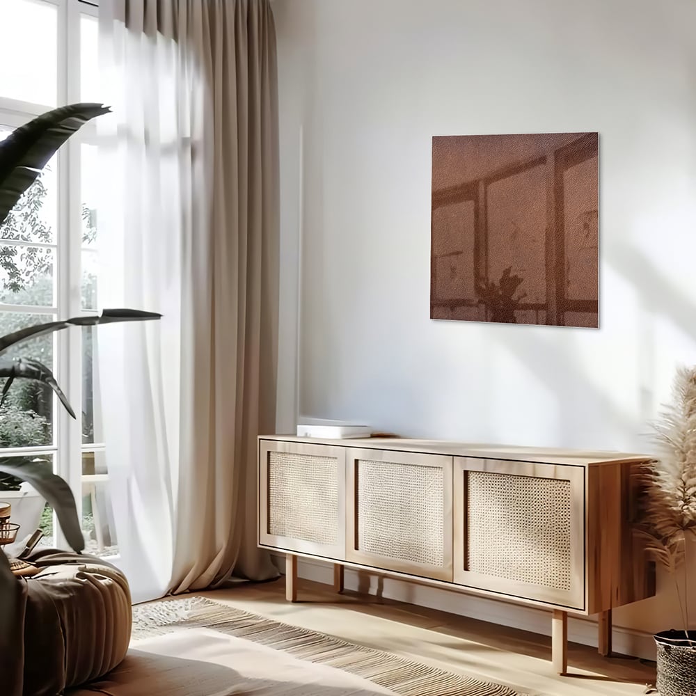 Glazen schilderij in aardetinten, op een witte muur boven een houten meubel.
