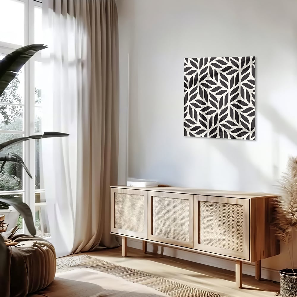 Zwart-wit glazen schilderij met bladerenpatroon aan de muur in een moderne woonkamer.