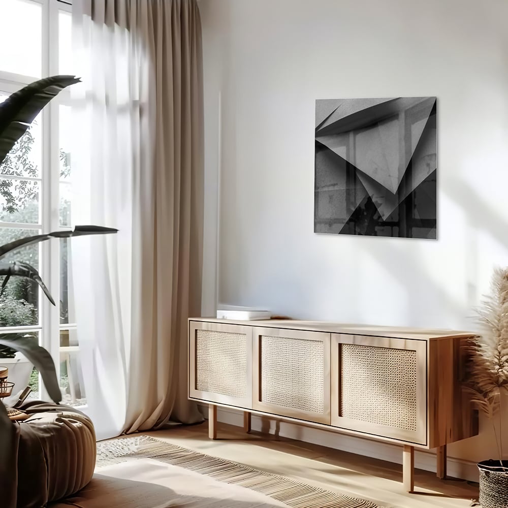 Modern glazen schilderij met een geometrisch zwart-wit ontwerp aan de muur.
