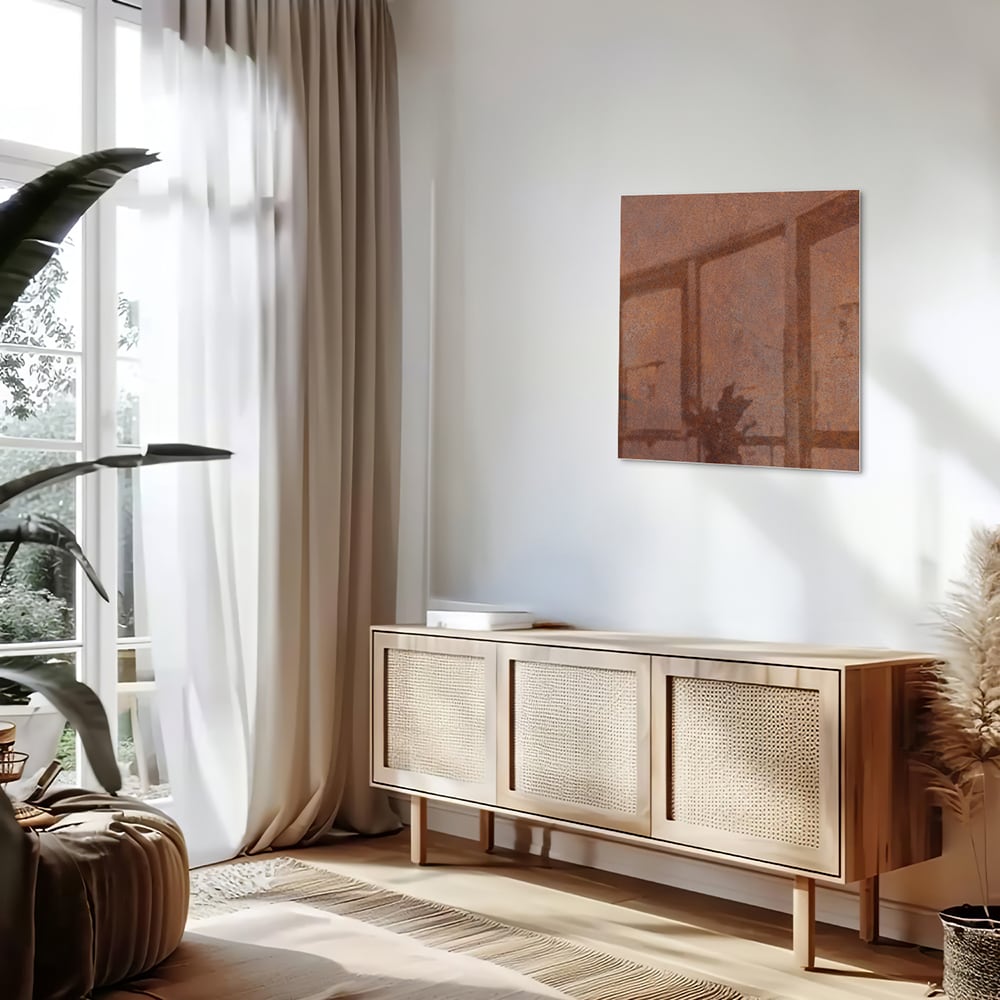 Abstract glazen schilderij met aardetinten boven een houten meubel.