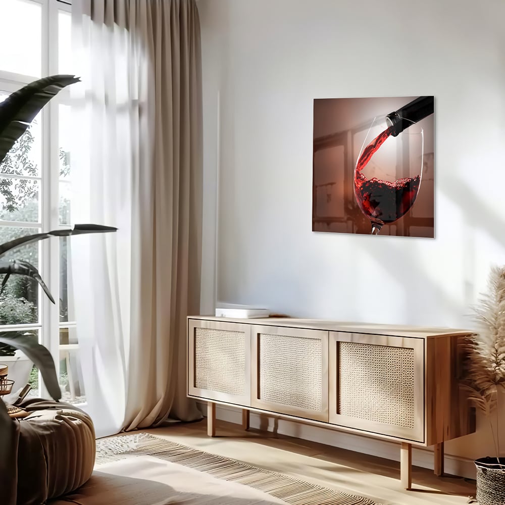 Glazen schilderij van een rode wijn die in een glas wordt ingeschonken, zichtbaar in een moderne woonkamer.
