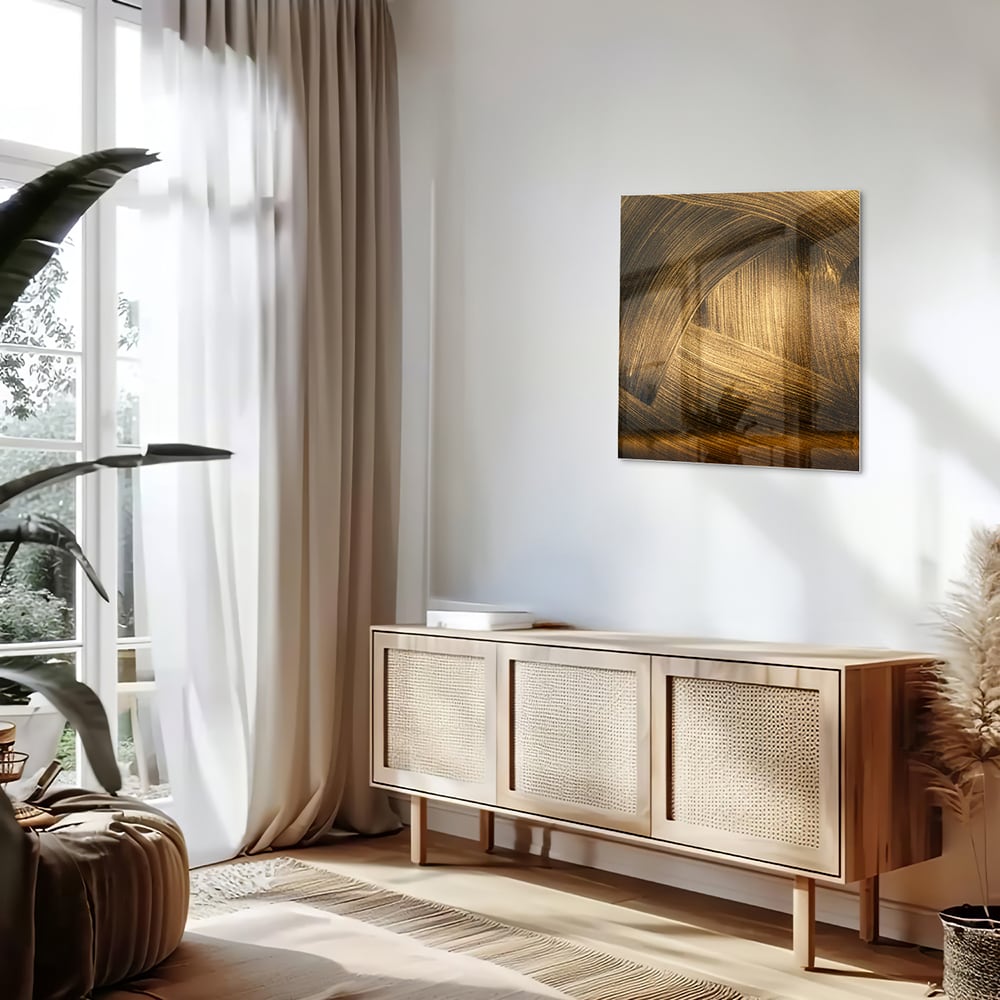 Glazen schilderij met gouden patronen aan de muur boven een houten meubel.
