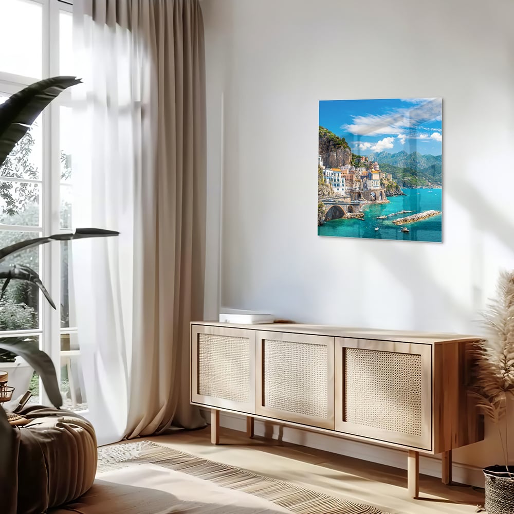 Glazen schilderij van een kustlandschap met blauwe zee en groene bergen.
