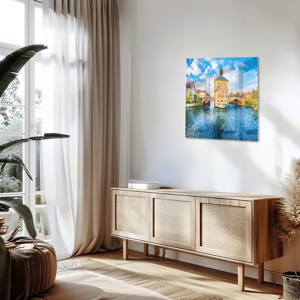 Glazen schilderij van een schilderachtig stadje aan het water met kleurrijke gebouwen en een helderblauwe lucht.