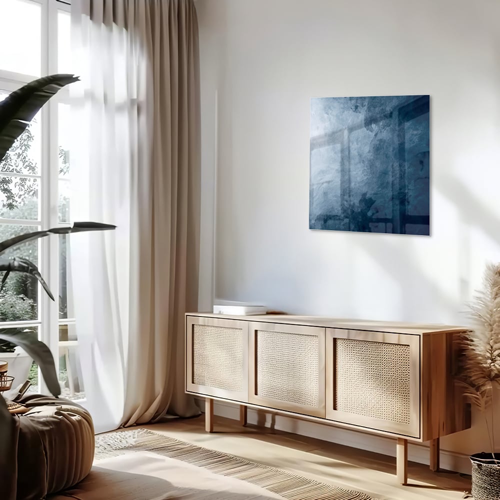Abstract blauw glas schilderij aan de muur bij een houten meubel.