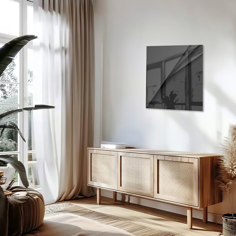 Zwart glazen schilderij aan een lichte muur in een modern interieur.