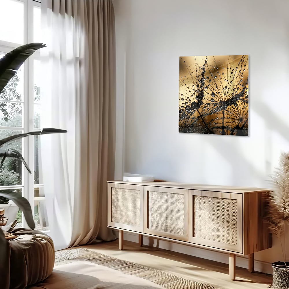Glazen schilderij met gouden waterdruppels op een lichte muur.
