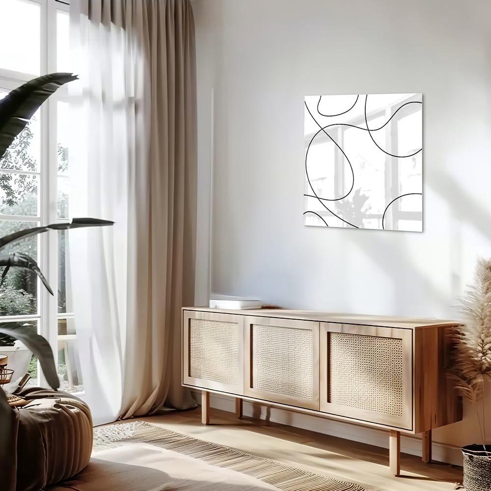 Glazen schilderij met elegante zwarte lijnen in een moderne woonkamer.
