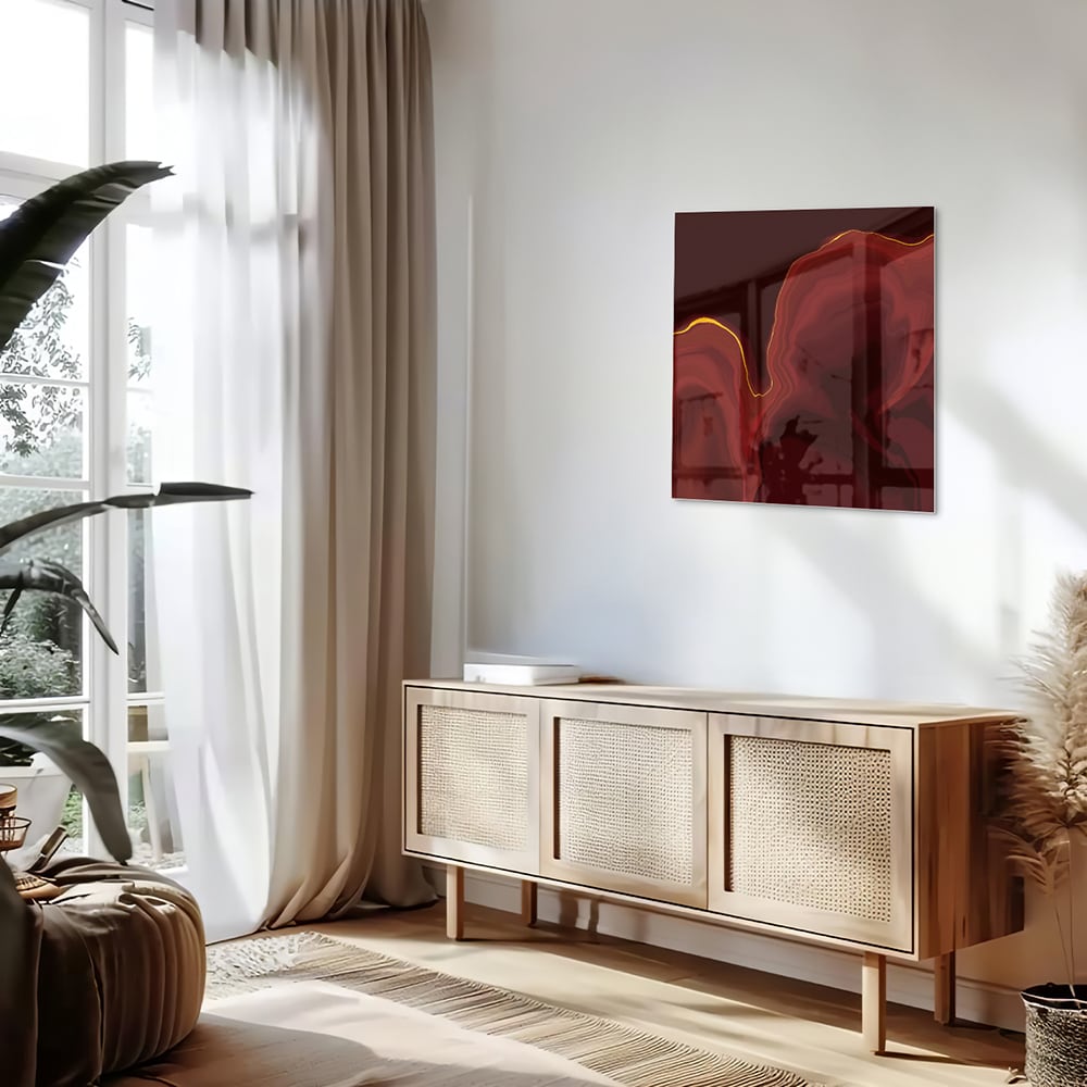 Abstract glazen schilderij met warme roodtinten aan de muur