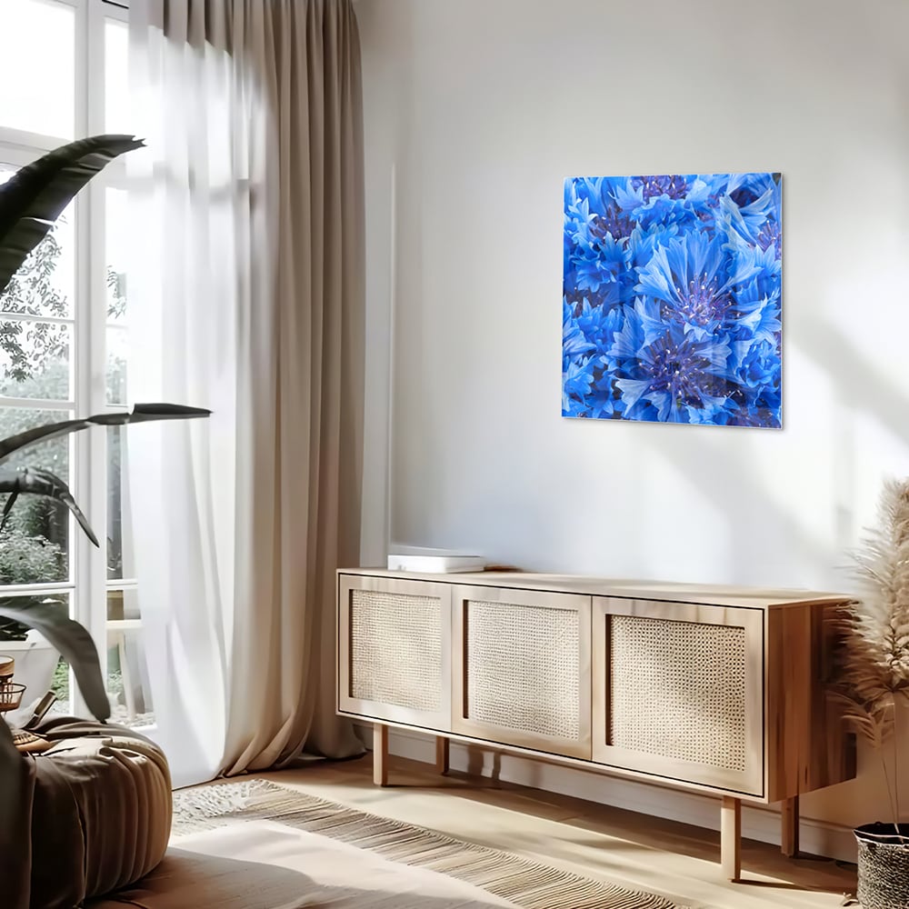 Glazen schilderij met een prachtig blauw bloemenmotief aan de muur
