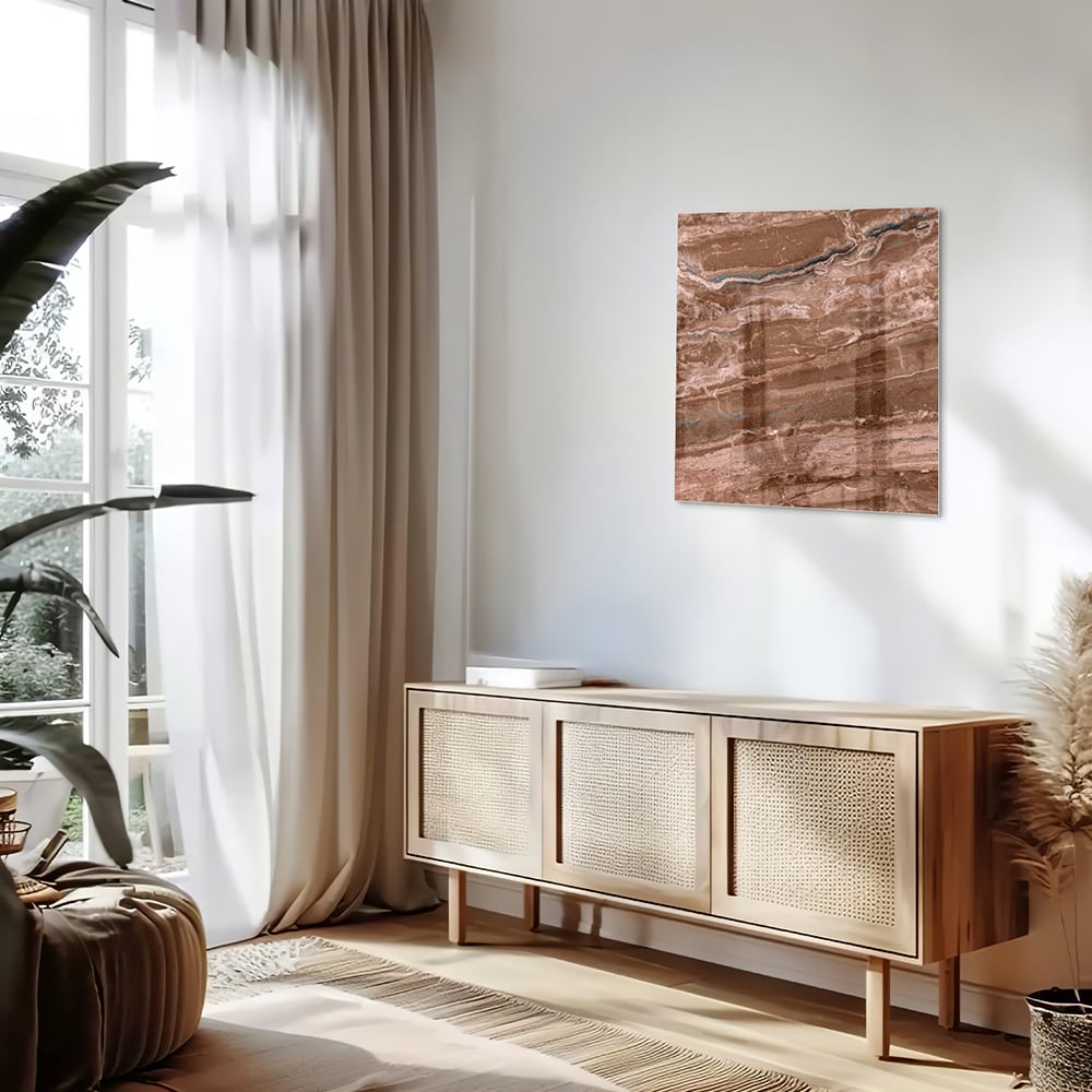 Glazen schilderij in aardetinten hangt aan een lichte muur boven een houten meubelstuk.