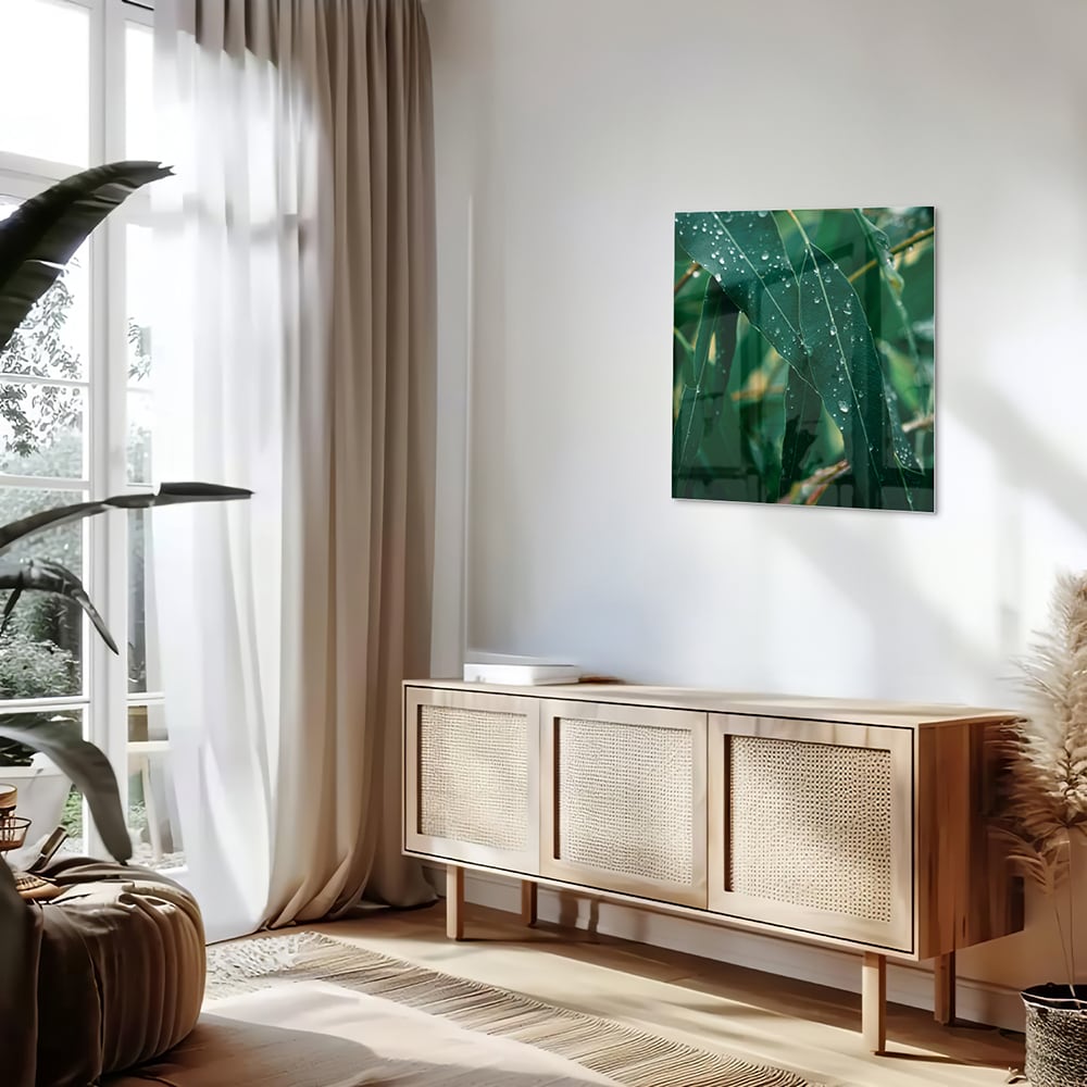 Glas schilderij van groene bladeren met dauwdruppels in een interieur