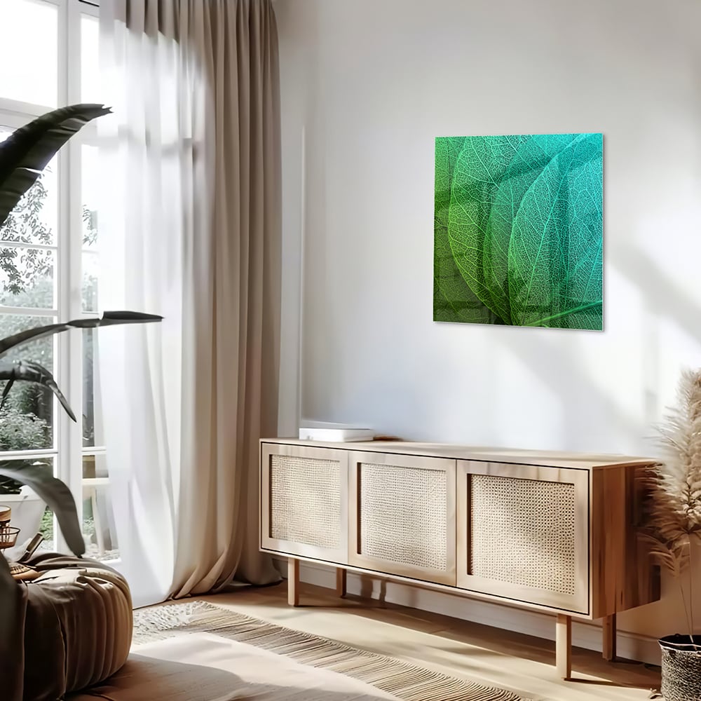 Glas schilderij met de structuur van groene bladeren aan een muur.